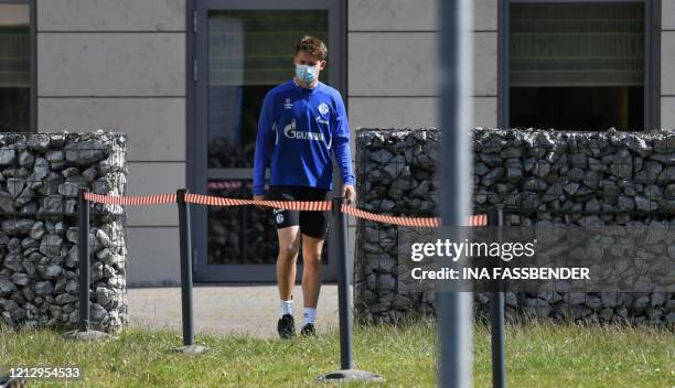 Schalke 04's German goalkeeper Alexander Nuebel walks with a face mask from the hotel, where the team stays in quarantine, to the club's training...