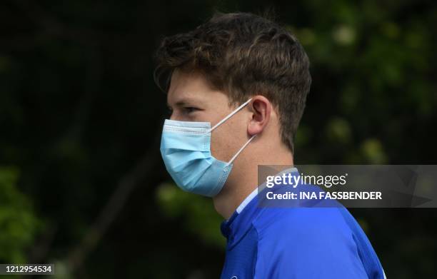 Schalke 04's German goalkeeper Alexander Nuebel walks with a face mask from the hotel, where the team stays in quarantine, to the club's training...