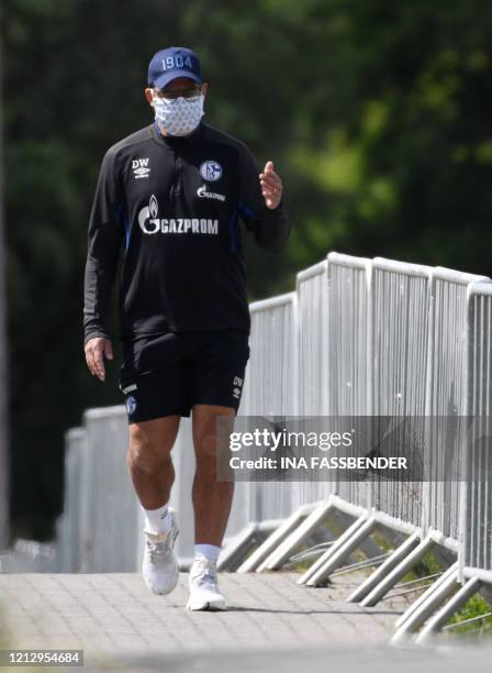 Schalke 04's German headcoach David Wagner walks with a face mask at the club's training grounds before a training session in Gelsenkirchen, western...