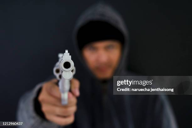 robber with a gun robbing intimidate.crime and robbery concept. - pistol stock pictures, royalty-free photos & images