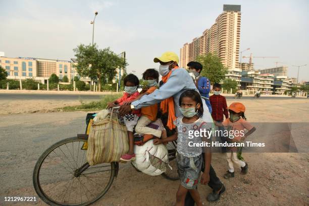 Migrant family with children were seen headed back to their village in Madhya Pradesh, near Gaur Chowk during lockdown, on May 13, 2020 in Noida,...