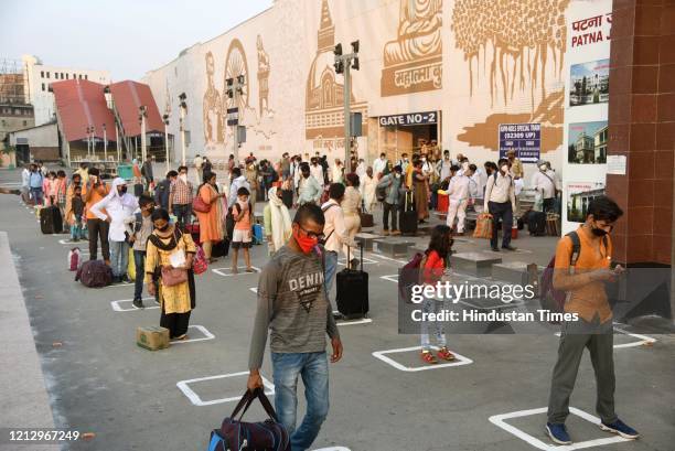 Passengers queue while keeping social distance waiting to board a Rajdhani Express train from Patna to Delhi, at Patna Junction, on May 13, 2020 in...