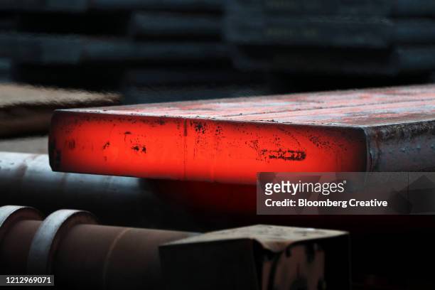 a steel slab at a foundry - iron roll stockfoto's en -beelden