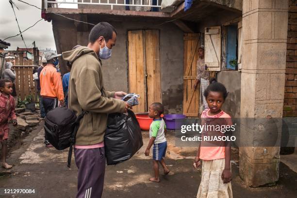 Safidy Andrianantenaina, one of the co-founders and co-managers of the association Le Caméléon walks in the district of Anjezika to distribute food...