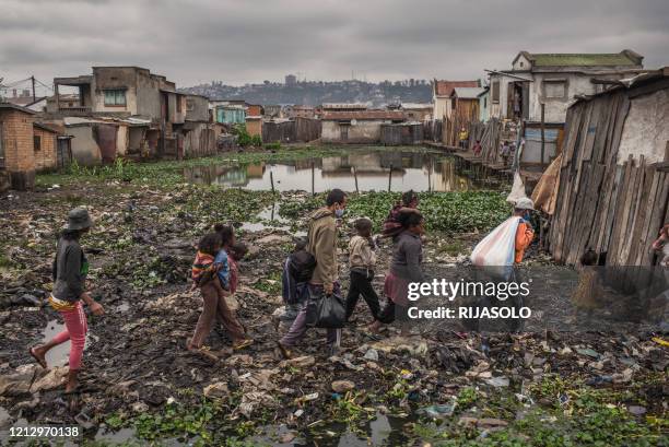 Safidy Andrianantenaina, one of the co-founders and co-managers of the association Le Caméléon walks in the district of Anjezika to distribute food...