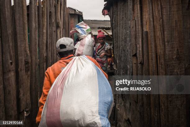 Residents of the Anjezika neighborhood help volunteers from the association Le Caméléon by transporting food parcels and clothing that will be...