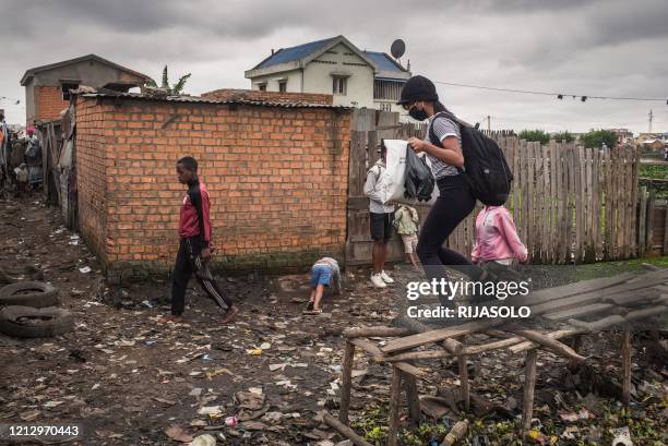 Volunteer of the association Le Caméléon walks in the district of Anjezika to distribute food parcels and face masks to its residents, in...