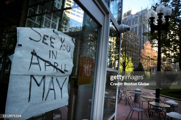 Sign hangs in the window at Sip Café in a near deserted Post Office Square in Boston, MA on May 13, 2020. Governor Charlie Bakers plan to reopen the...