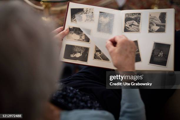 In this photo illustrationan old woman looks into a photo book on May 12, 2020 in Radevormwald, Germany.