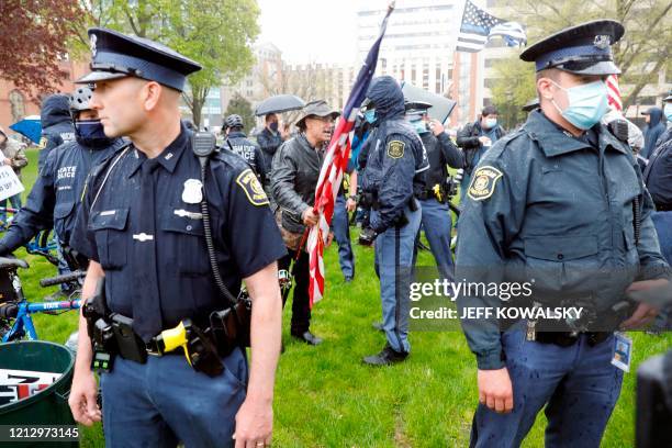 Michigan State Police patrol as demonstrators protest in Lansing, Michigan, during a rally organized by Michigan United for Liberty on May 14 to...