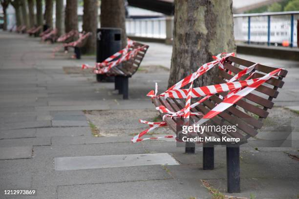 Benches on the South Bank are taped off to prevent people sitting down and so to preserve social distancing as lockdown continues and people observe...