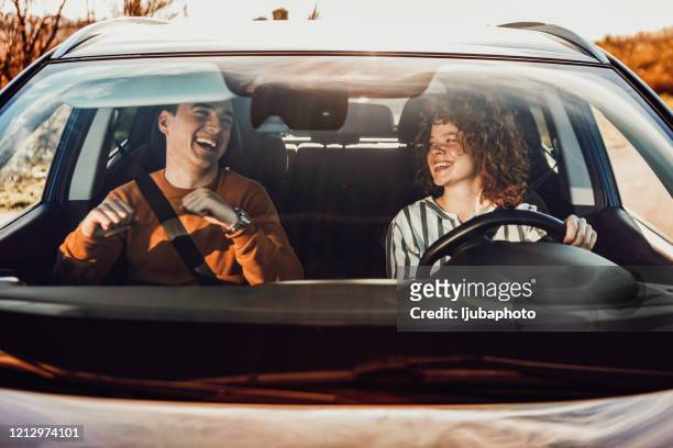 felice giovane coppia godendo in auto - punto di vista frontale foto e immagini stock