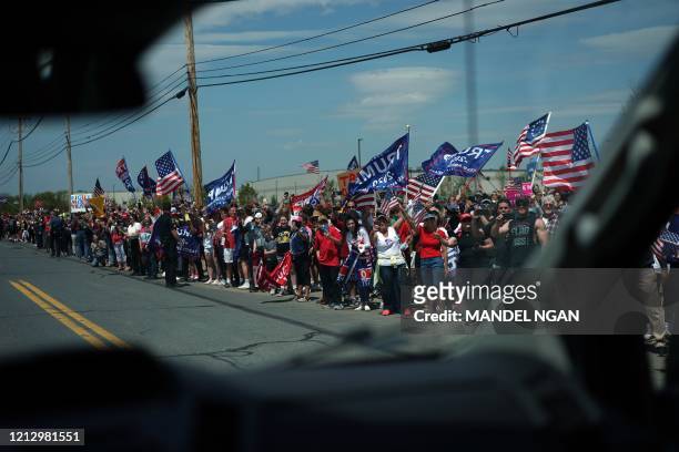 Image taken from the press van shows Trump supporters holding signs before US President Donald Trump visits medical supply distributor Owens and...