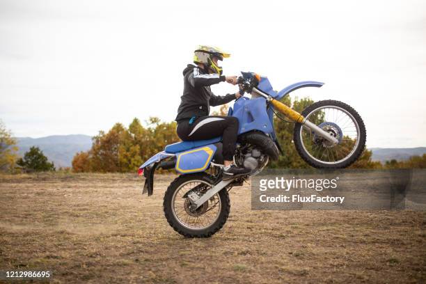 professional bike rider doing a wheelie - wheelie stock pictures, royalty-free photos & images