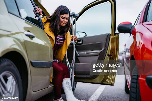 woman with cast getting out of car - crutch stock pictures, royalty-free photos & images