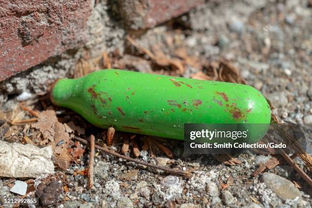 Close-up of miniature cylinder of nitrous oxide, a drug of abuse referred to as Whip Its, Whipits or Whippets, discarded in a gutter in Walnut Creek,...