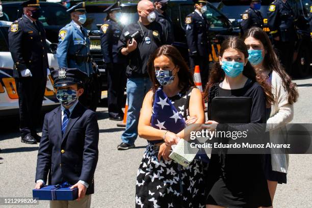 Alice Roberts holds an American flag alongside her children Gavin, Shea and Natalie during the funeral of her husband, Glen Ridge Police Officer...