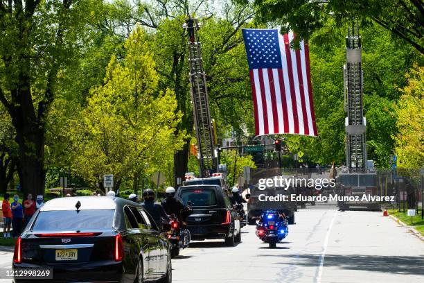 Huge American flag hangs over the procession during the funeral of Glen Ridge Police Officer Charles Roberts after he passed away from the...