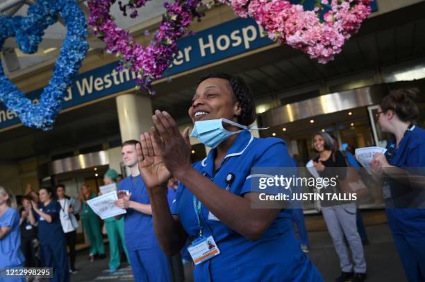 Workers participate in a national "clap for carers" to show thanks for the work of Britain's NHS workers and other frontline medical staff around the...