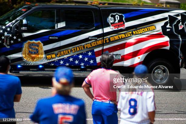 Residents watch the procession during the funeral of Glen Ridge Police Officer Charles Roberts after he passed away from the coronavirus, on May 14,...