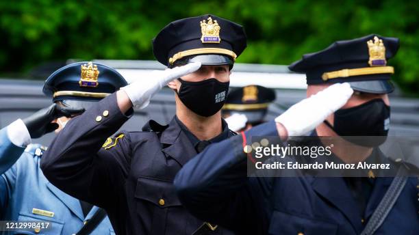 Police officers pay their respects during the funeral of Glen Ridge Police Officer Charles Roberts after he passed away from the coronavirus, on May...