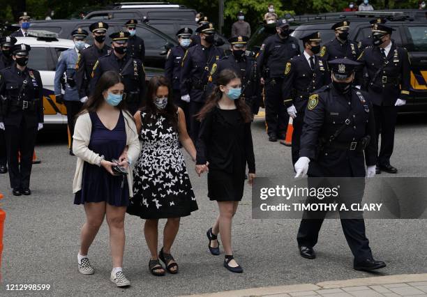 The wife and daughters of Charles Roberts follow, as the pallbearers carry in the casket of Glen Ridge Police Officer Charles Rob Roberts who died of...