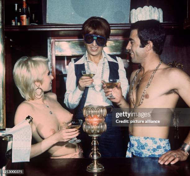 Ein nackter junger Mann, der nur mit einem Tangaslip und einem Schal um die Hüften bekleidet ist, trinkt am 5.9.1975 in der Maskulin-Bar in Hannover,...
