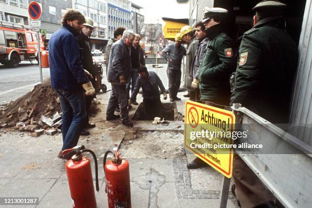 Arbeiten an einem städtischen Gasrohr in Hannover 1986. Die Baustelle ist mit Warnschildern gekennzeichnet, zur Sicherheit stehen Feuerlöscher und...