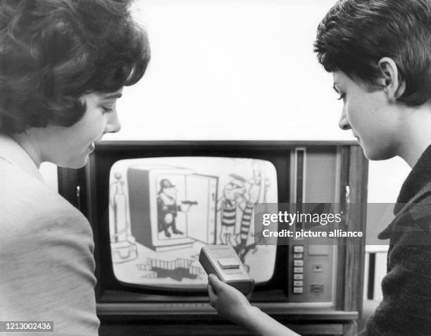 Zwei junge Frauen sitzen 1962 in Hannover mit einer Fernbedienung in der Hand vor einem neuen Fernsehgerät mit asymetrischem Gehäuse. Fast alle...