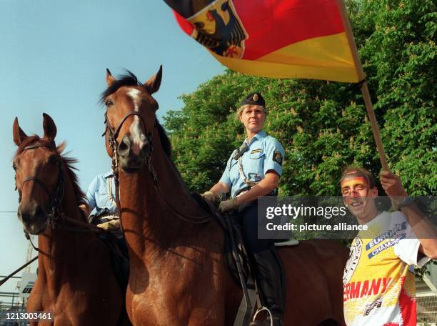 Berittene Polizisten und ein deutscher Fußball-Fan in voller "Kriegsbemalung" im Einzugsbereich des Stadions von Norrköping, wo am das erste...