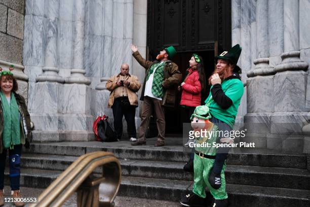 People celebrate St. Patrick's Day even as the parade was cancelled in front of St. Patrick's Cathedral on March 17, 2020 in New York City. Schools,...