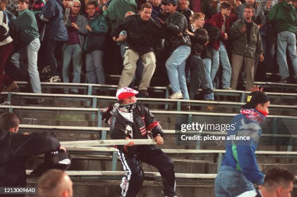 Bewaffnet mit einer aus den Sitzreihen herausgerissenen Latte treibt ein deutscher Hooligan während des Fußball-Länderspielspiels Polen - Deutschland...