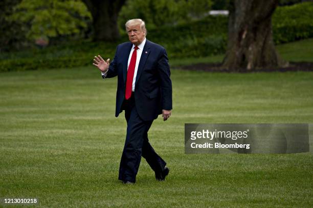 President Donald Trump waves while walking on the South Lawn of the White House after arriving on Marine One in Washington, D.C., U.S., on Thursday,...