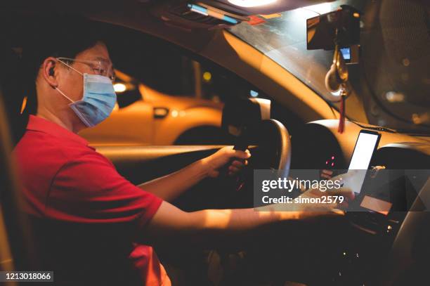 e-hailing homem asiático com máscara facial usando smartphone - driving mask - fotografias e filmes do acervo