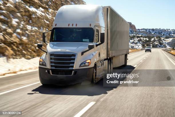 a cloes-up view of a long haul semi truck speeding down the highway - truck front view stock pictures, royalty-free photos & images