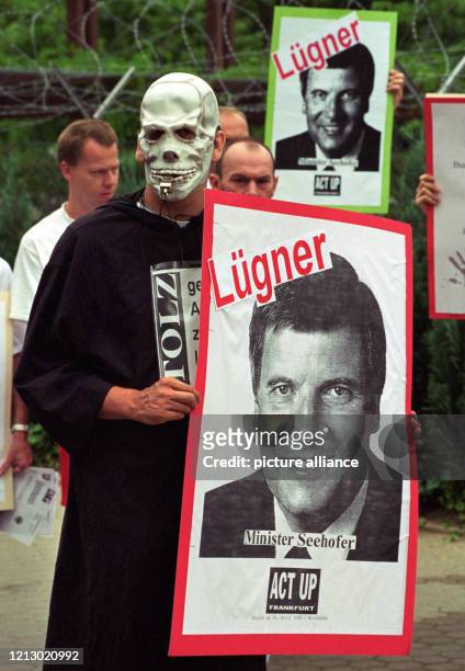 Ein Demonstrant mit der Maske eines Totenschädels und einem Plakat mit dem Porträt von Gesundheitsminister Horst Seehofer und der Aufschrift "Lügner"...