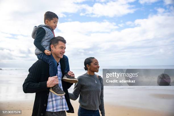 daddy carrying toddler on shoulders on family walk on beach - newport beach california stock pictures, royalty-free photos & images