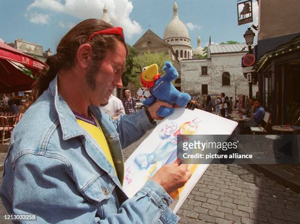 Ein Pariser Straßenmaler malt am 11.6.1997 an der Place du Tertre Footix, das Maskottchen der 16. Fußball-Weltmeisterschaft 1998 in Frankreich, das...