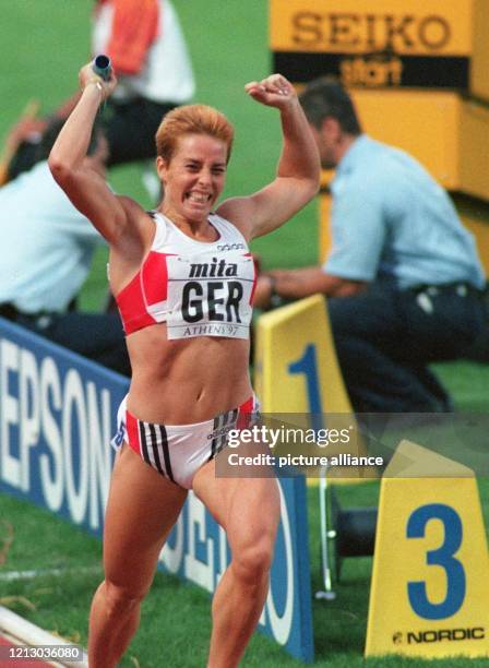 Die deutsche 400-m-Läuferin Grit Breuer reißt beim Passieren des Zielstrichs jubelnd beide Arme hoch am 10.8.1997, dem Schlußtag der 6....