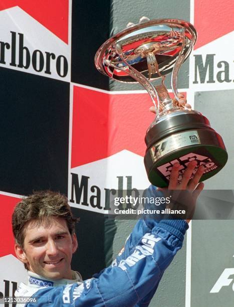 Der englische Formel 1-Weltmeister Damon Hill bejubelt am 10.8.1997 bei der Siegerehrung nach dem Großen Preis von Ungarn auf dem Hungaroring in...