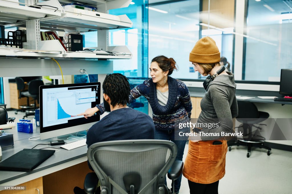 Scientists examining data on computer while working in research lab