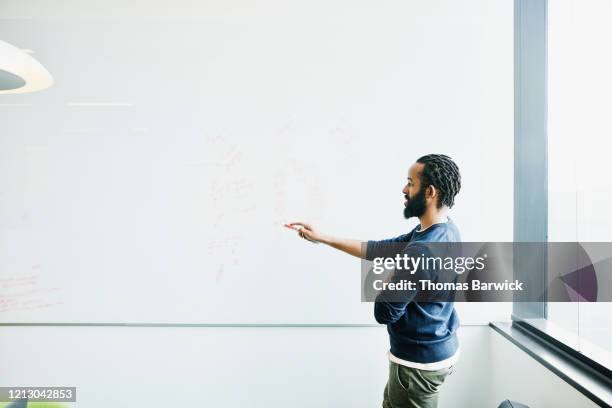 scientist explaining data on whiteboard in conference room - businessman challenge stock pictures, royalty-free photos & images