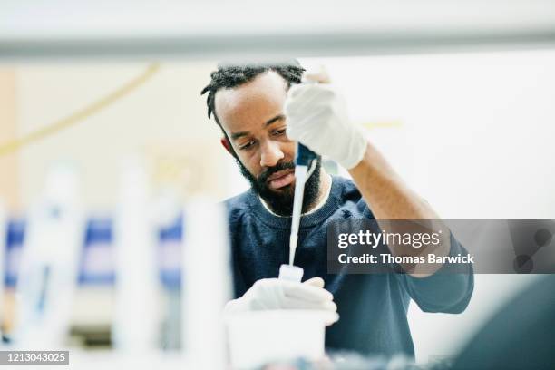 scientist pipetting samples in research lab - biotechnology lab stock-fotos und bilder