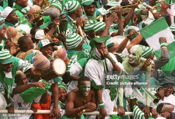 In den grün-weißen Landesfarben bemalte und gekleidete Fußball-Anhänger von Nigeria feiern am 13.6.1998 auf den vollen Traversen des Stade La...