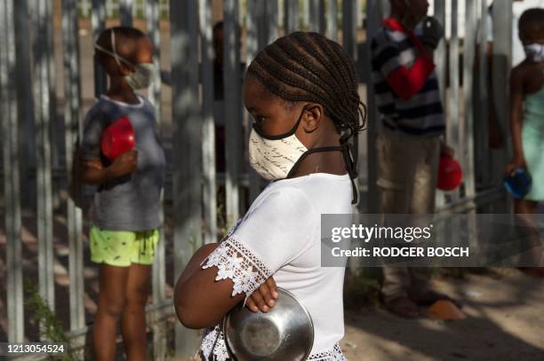 Children wait in lines at a crèche in Langa, near Cape Town on May 14 to receive a meal, which will include soup made by Woodstock Breweries, which...