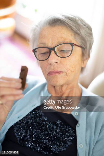 In this photo illustration an old woman is eating an chocolate bar on May 12, 2020 in Radevormwald, Germany.