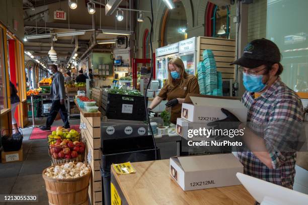 Joe Von Allmen and Katy Roberts of ETC Produce and Provisions prepare orders for customers at Findlay Market as businesses begin to reopen in the...