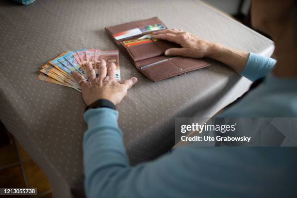 In this photo illustration you find cash next to a purse and the hands of an old woman on May 12, 2020 in Radevormwald, Germany.