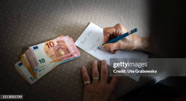 In this photo illustration a pensioner makes a written statement of her expenses on May 12, 2020 in Radevormwald, Germany.