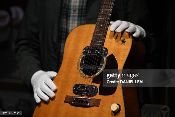 Co-owner of Julien's Auctions, Martin Nolan displays the guitar used by musician Kurt Cobain during Nirvana's famous MTV Unplugged in New York...